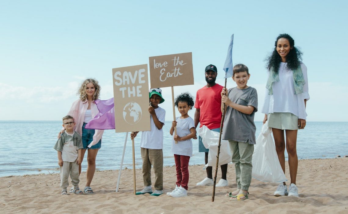 Community trash pick up group standing together at the beach