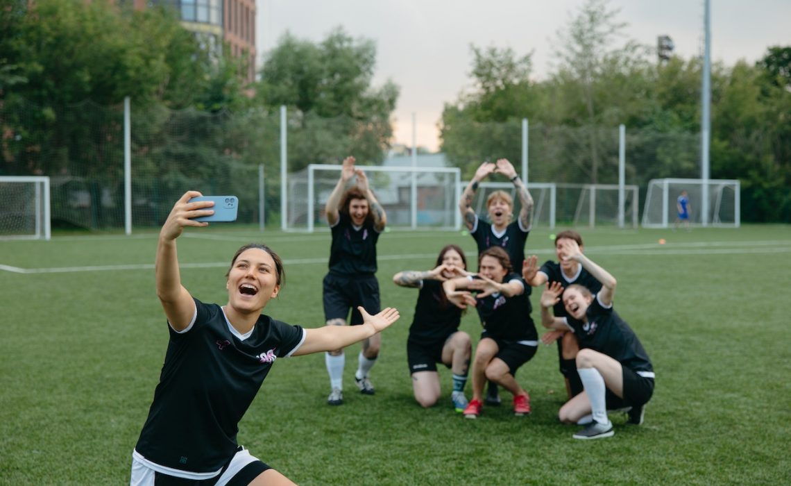 Sports team taking a group photo on the soccer field