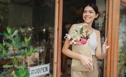 Woman inside her flower shop holding a bouquet