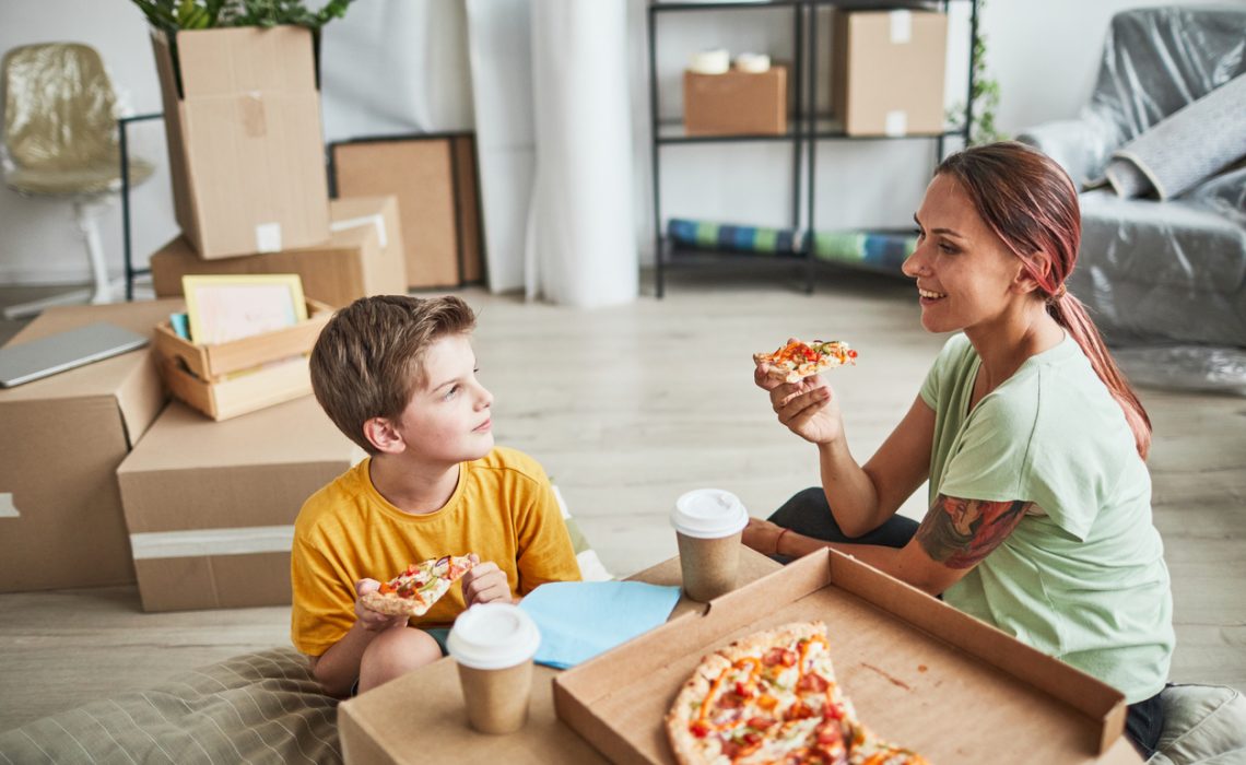 Mother and Son Eating Pizza in New Home