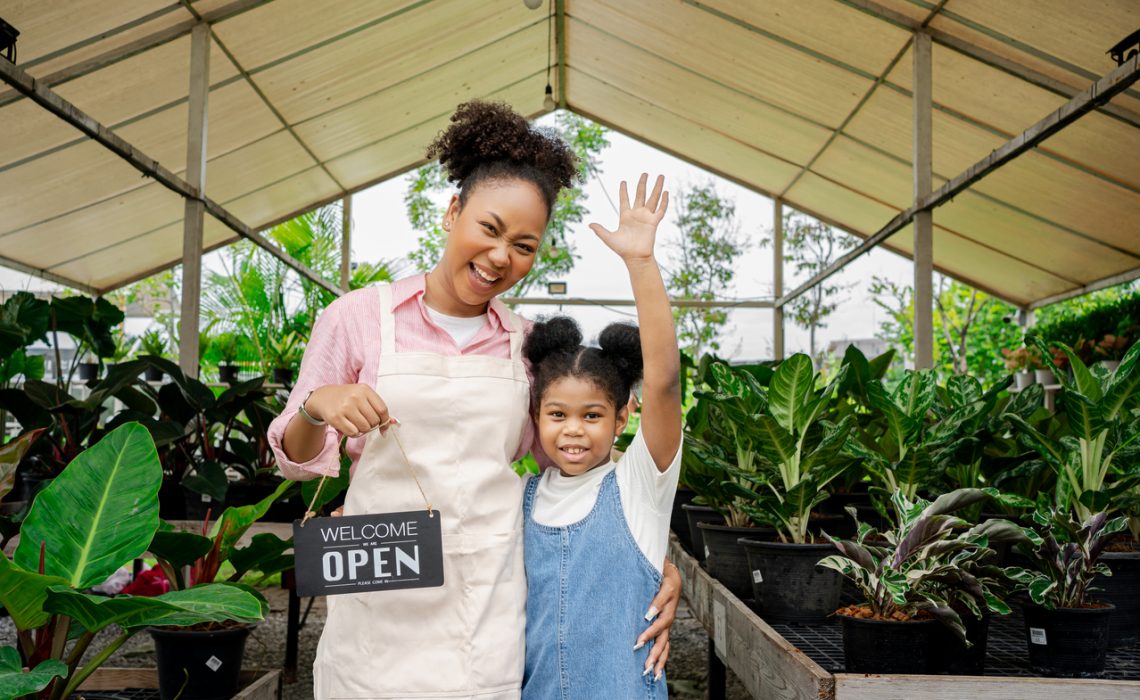 African American Single mom and her daughter in her green plant shop.Family Hands Together Teamwork Shop Small Business.green business for young activity help her mom.'s women-owned business