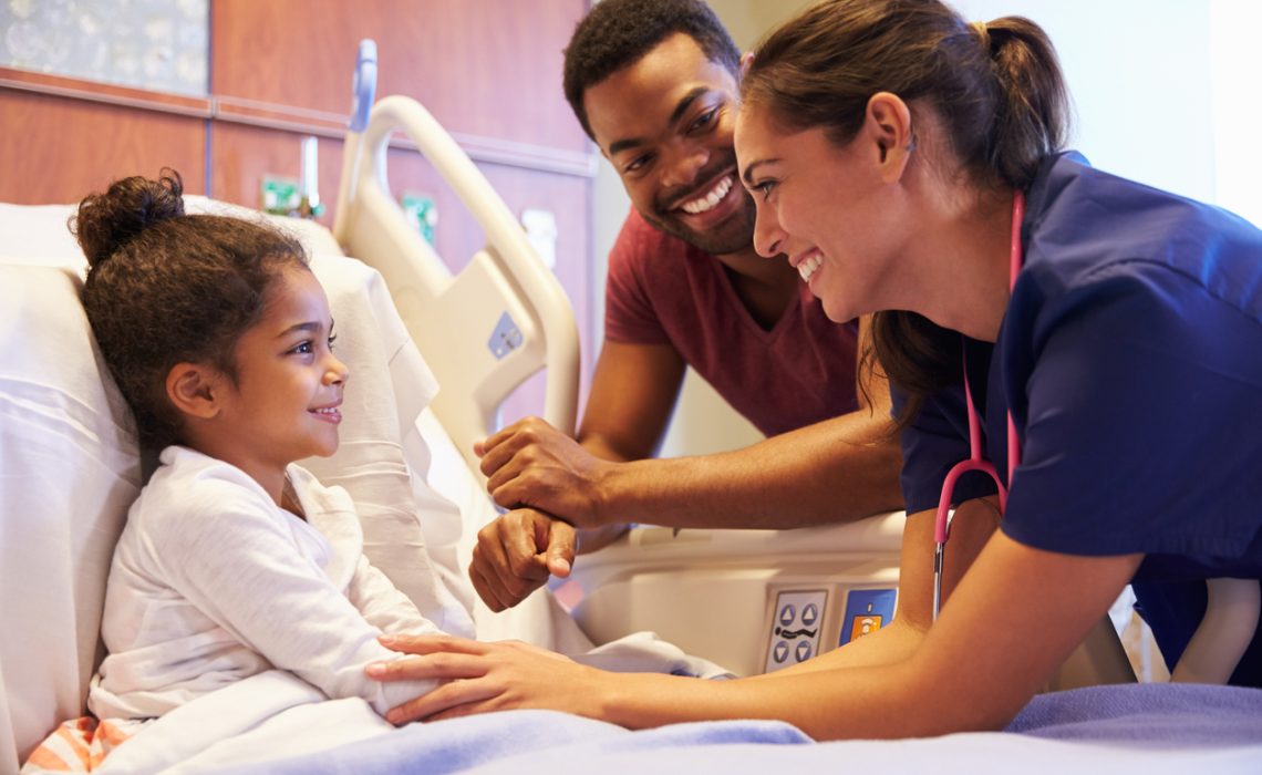 Pediatrician Visiting Father And Child In Hospital Bed stock photo