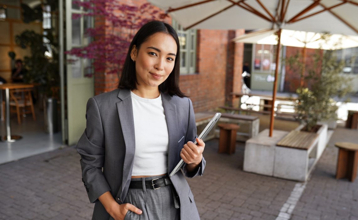 Young professional leader Asian woman manager wearing suit, outdoor portrait.
