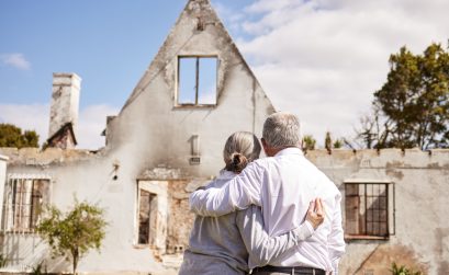 senior couple comforting each other after losing their home to a fire