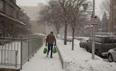 Man walking with groceries in a winter storm