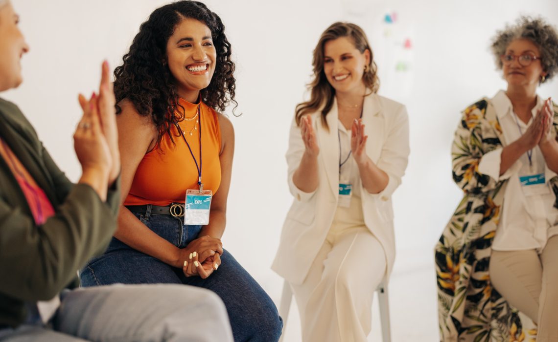 Happy businesswomen applauding their team mate during a meeting